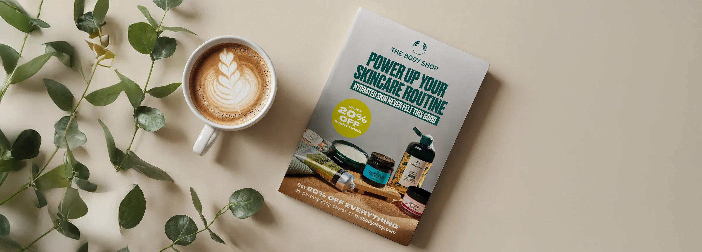 The Body Shop's skincare catalogue laid flat beside a coffee and eucalyptus