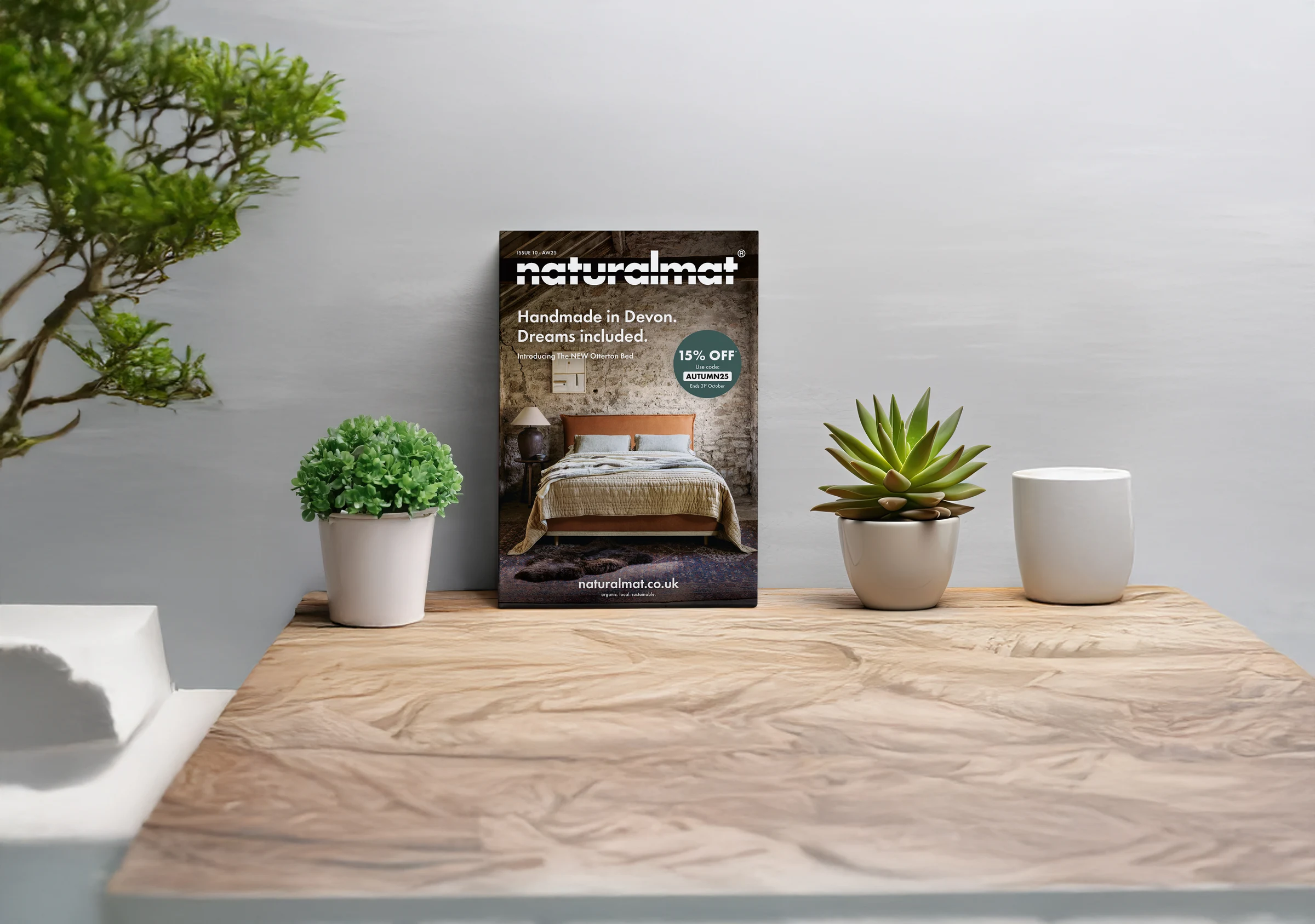 Naturalmat's redesigned catalogue standing on a shelf, styled with plants